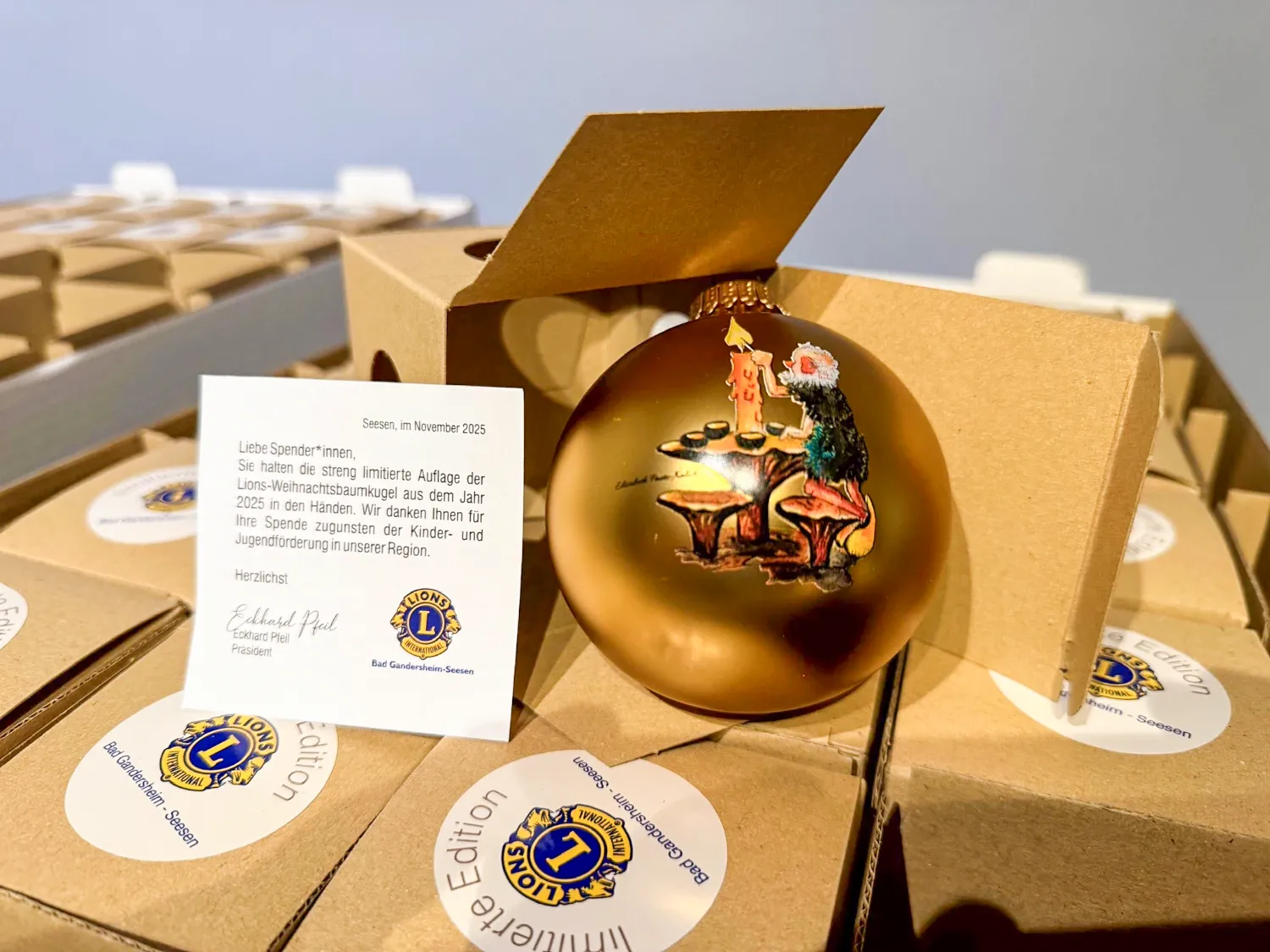 Goldene Weihnachtskugel 2025 mit Mooswicht-Motiv, Geschenkverpackung und Begleitkarte